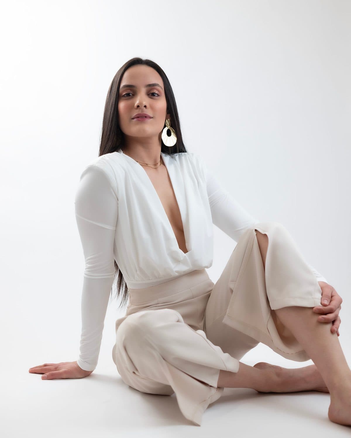 Retrato de marca personal con conjunto blanco, pose sentada sobre fondo claro