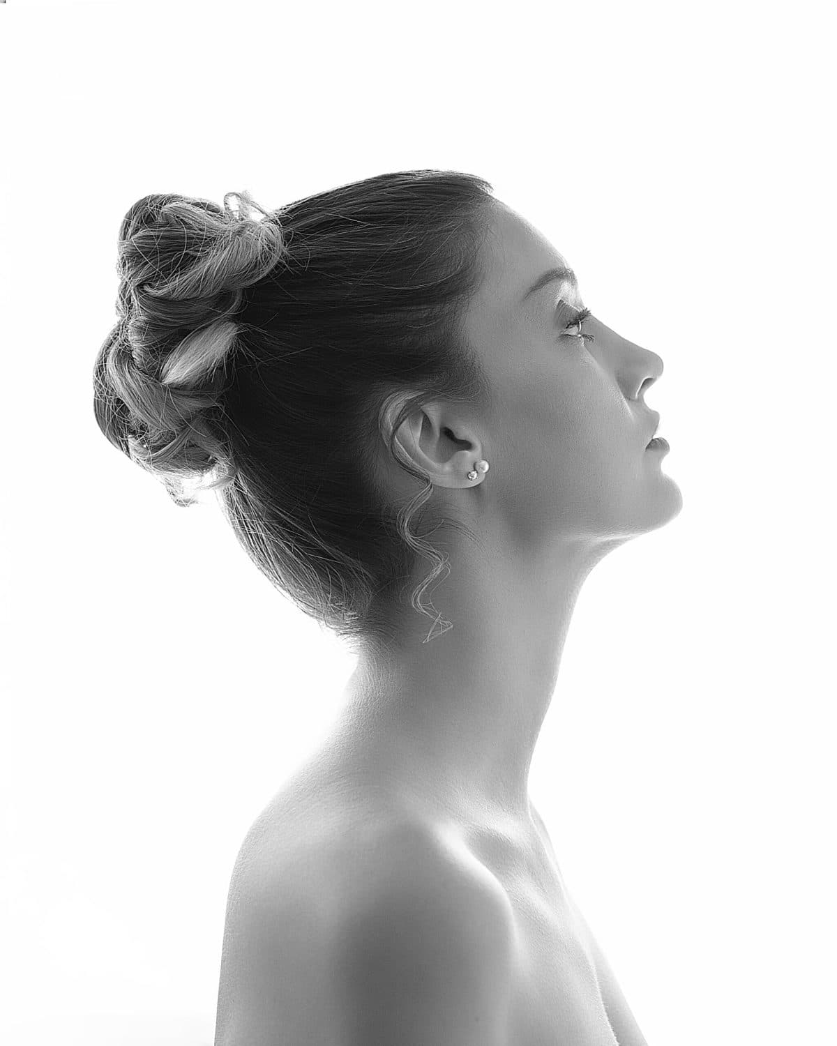 Retrato editorial en perfil, silueta en blanco y negro sobre fondo claro