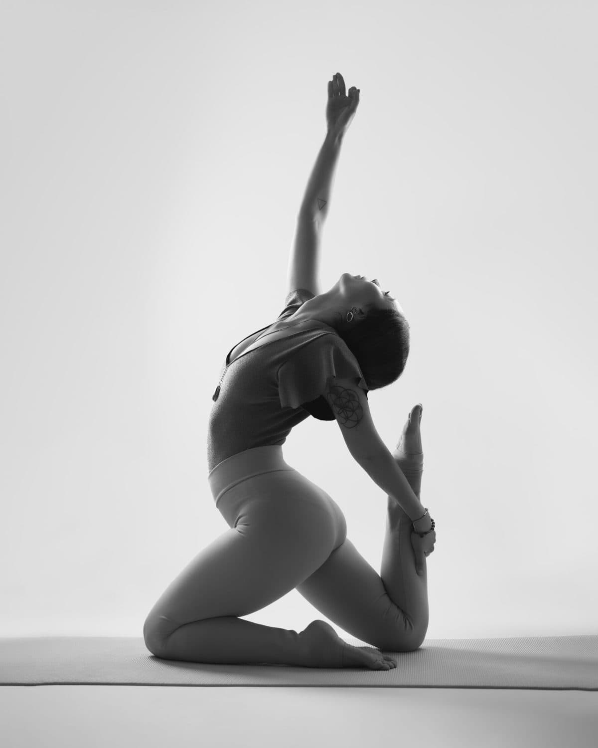 Retrato de yoga en blanco y negro, postura de estiramiento arrodillada con brazo extendido