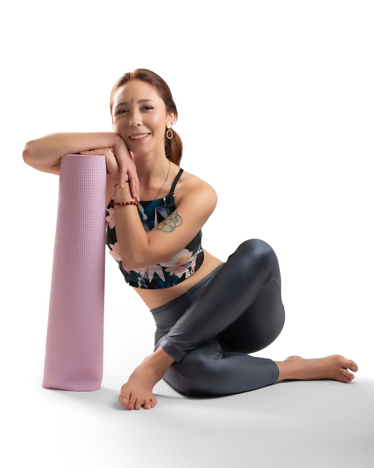 Retrato de yoga a color, sentada en el suelo con las piernas cruzadas
