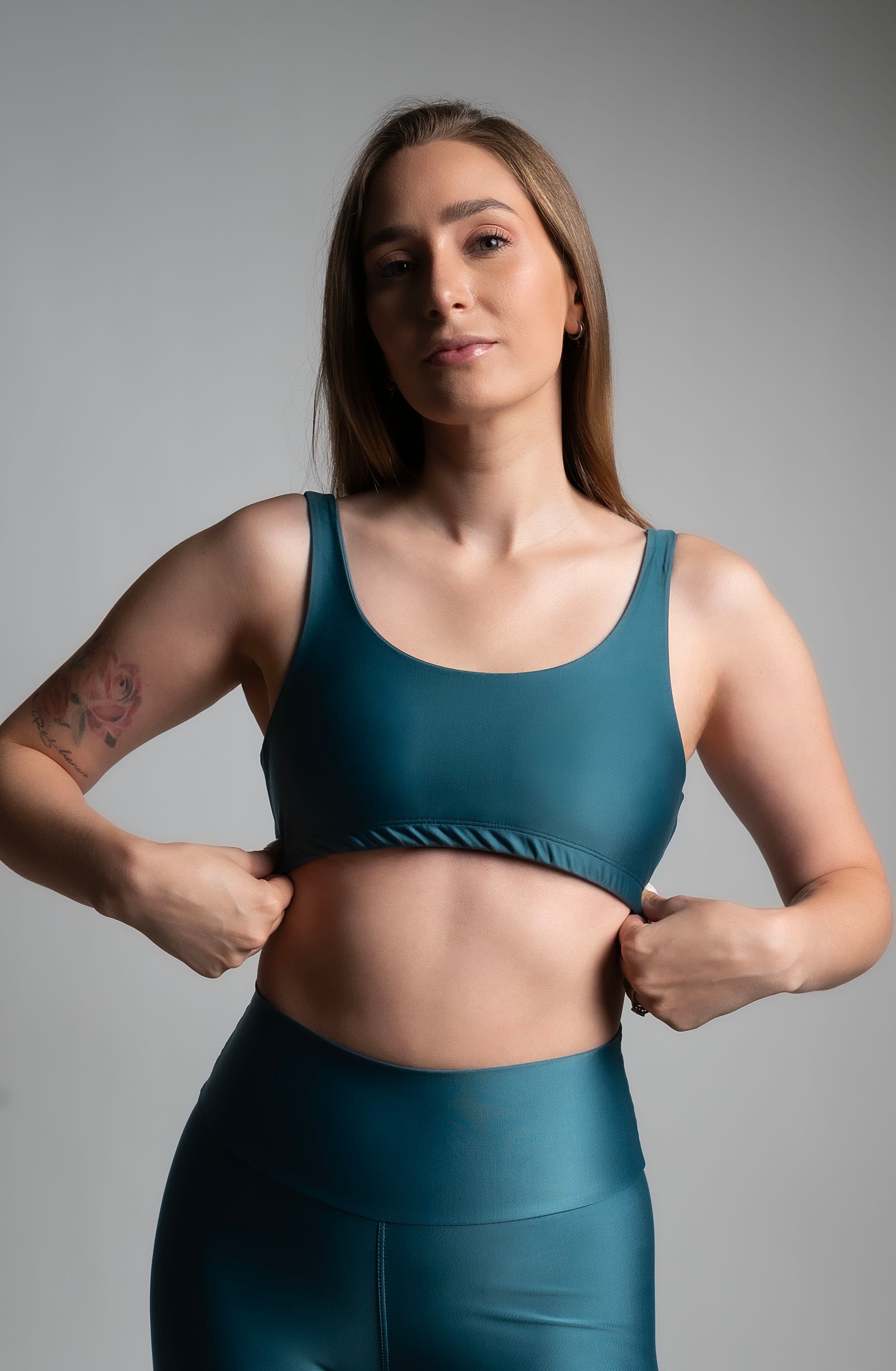 Fotografía comercial de ropa deportiva, conjunto verde azulado, medio cuerpo sobre fondo de estudio